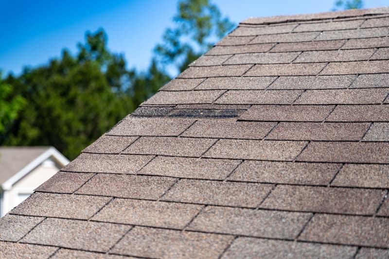 Worn asphalt shingles with a tab missing